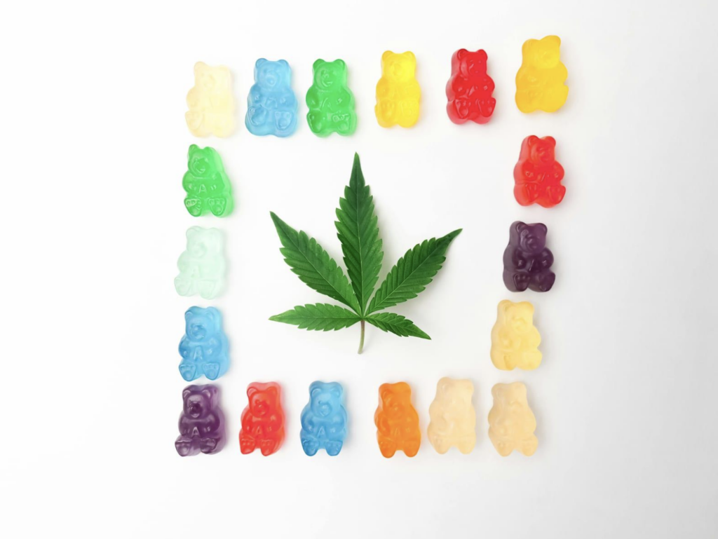 Gummies surrounded around a cannabis leaf.